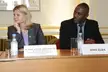 Idris Elba in a black suit and Justine Greening in a grey blazer sitting at a table with nameplates.
