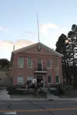 Lander County Court House, a tall red brick building with a flagpole under a pale sky.