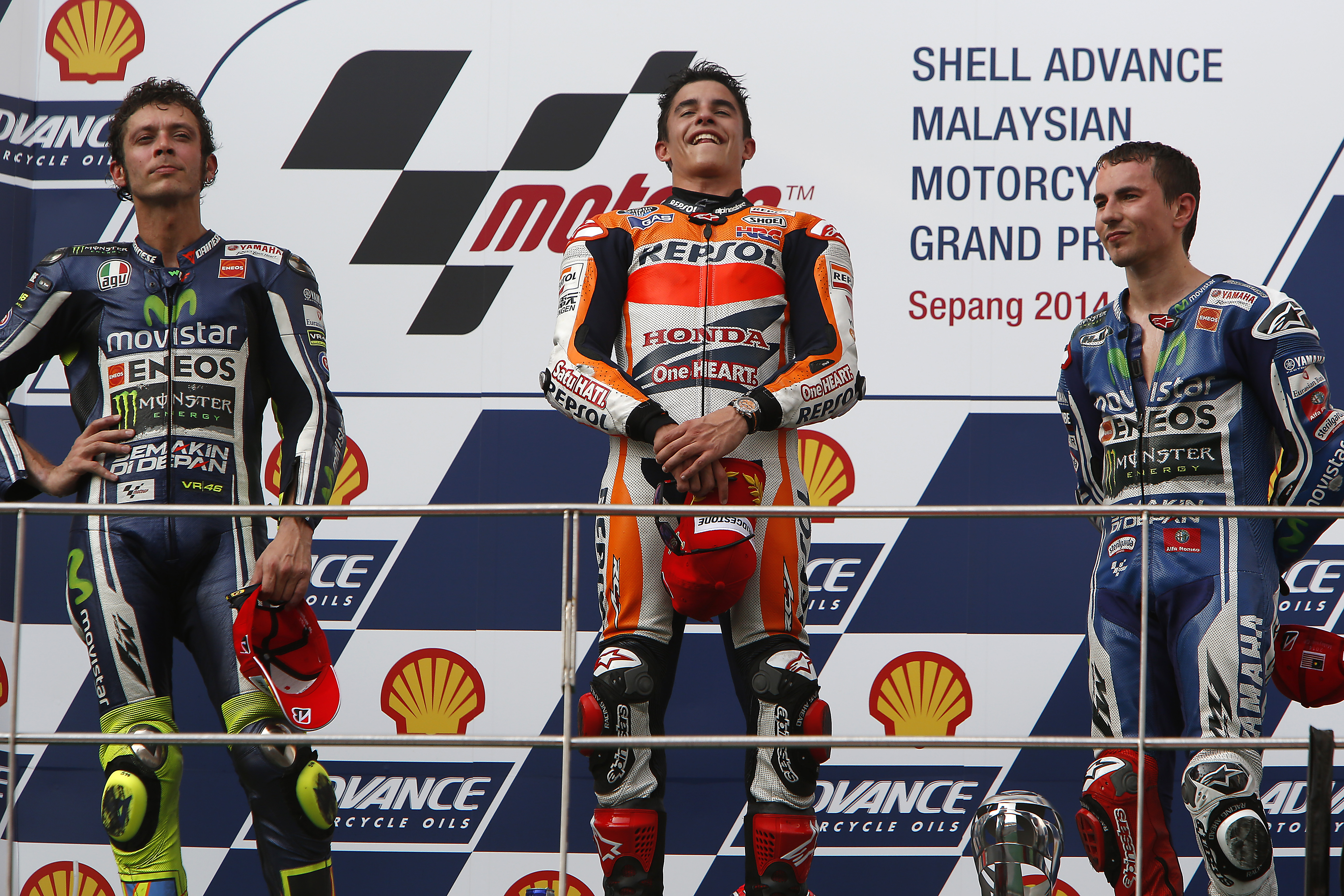 Valentino Rossi, Marc Márquez and Jorge Lorenzo, celebrating on the podium after finishing second, first and third at the MotoGP race.
