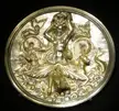 Gold relief sculpture of a topless woman and sea creatures on a Pyxis with Scylla