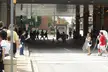 Otakon 2006 attendees in casual streetwear and costumes walking under a concrete overhang