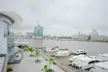 Lagos State Ferry Services Corporation boats docked at a pier with the city skyline and a tall green building