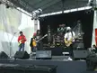 KAMI performing at The Gig Seremban with electric guitars, drums, and amplifiers on an outdoor stage.