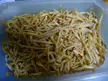 Dried and salted cod fried strips in a clear plastic container