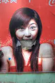 Kakia in a red strapless off-the-shoulder dress on a torn Coca-Cola advertisement poster