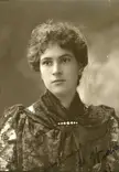 Grace Alekhine in a vintage black and white close-up wearing a dark lace top with a pearl brooch