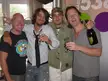 Kane and three friends smiling and posing with champagne glasses and a bottle indoors