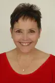 Levana Finkelstein, a woman with short brown hair wearing a red v-neck top and pearl jewelry.