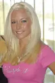 Kendra Wilkinson smiling in a pink t-shirt
