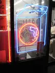 Neon socks fashion featuring a blue neon detergent bottle sign in a laundromat storefront window