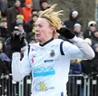 Jacob Ericsson in a white long-sleeved jersey and black gloves on a soccer field with a crowd behind him