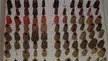 Colorful thread spools on a white pegboard in Natalia Romano's studio