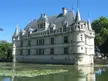 Château d'Azay-le-Rideau, a white stone castle with pointed turrets reflected in a pond with lily pads.
