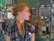 Beautiful woman with a blonde ponytail, plaid shirt, and yellow scarf posing against circuit boards