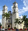 Pueblos Mágicos landscape photography of a stone cathedral with tall bell towers and tropical palm trees