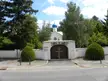 Sainte-Geneviève-des-Bois Russian Cemetery church with a blue dome, white wall, and wooden gate with a gold cross