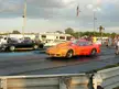 Black and orange race car with flame decals lined up on a drag strip for Heads Up Madness