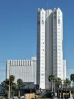 Tropicana Las Vegas resort building with palm trees and a city skyline under a clear blue sky