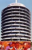 Capitol Records Building behind a colorful mural of a group of people in white shirts and diverse clothing
