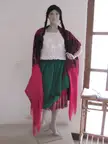 Typical dress of a chola cuencana featuring a white lace top, green skirt, and a pink and black patterned shawl