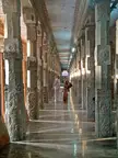 A couple walking through the carved stone pillars of the Meenakshi Temple in Madurai, India