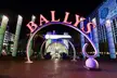 Bally's neon sign and illuminated archway leading to a station entrance in Las Vegas with palm trees