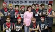 EXO and Park Geun-hye posing together in front of a banner with Korean and Chinese text