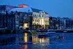 Winter desktop wallpaper 4k of a city waterfront at night with snow-covered buildings and boats on a frozen canal