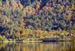 Patagonia landscape with autumn foliage in green, orange, and red reflecting in a calm lake