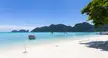 Phi Phi Don beach with turquoise water, white sand, and boats anchored near rocky mountains