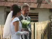 A couple in vintage family photos attire; a woman in a white wedding dress and veil and a man in a grey suit.
