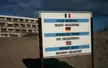 A sign on the sandy beach at Cap d'Agde with text in French, German, and English