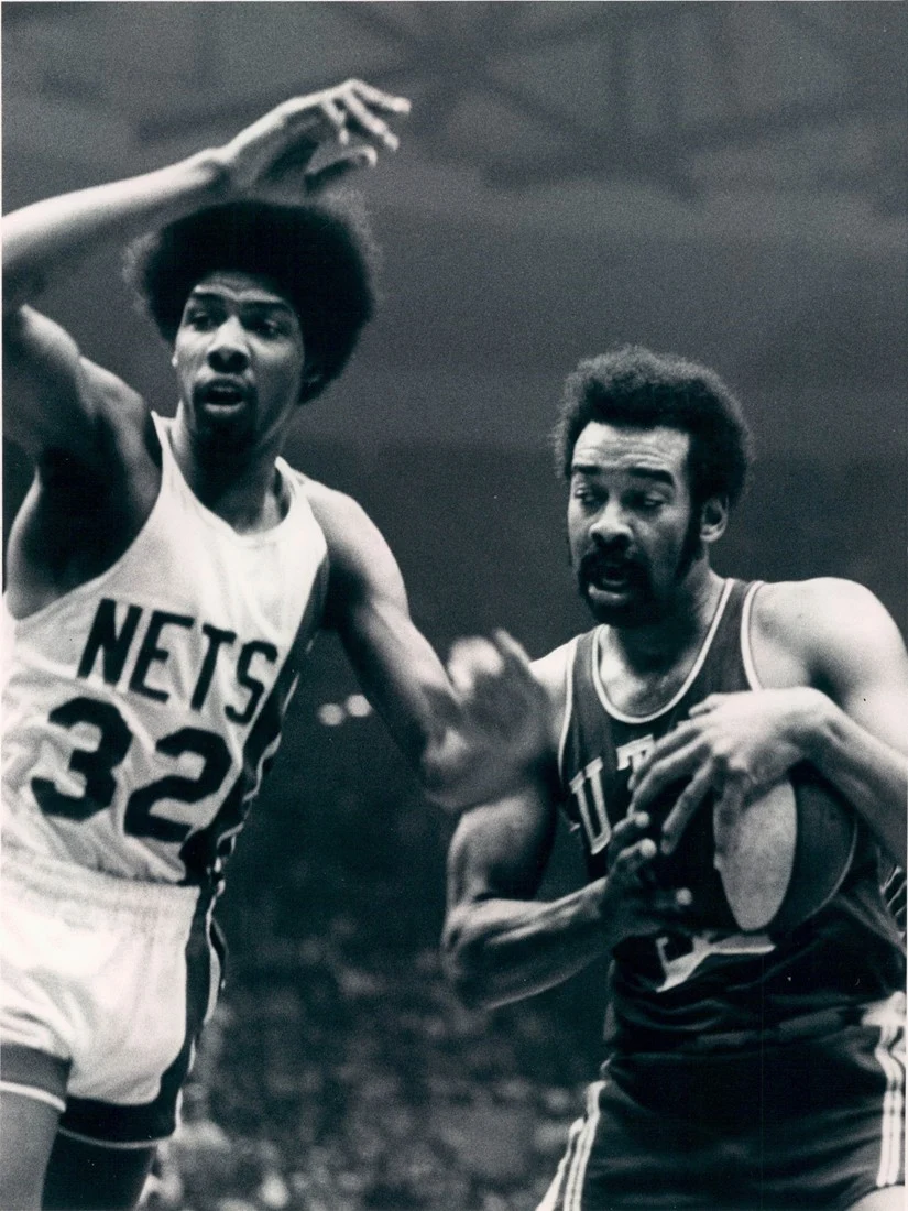 Wise being guarded by New York Nets player Julius Erving.