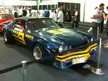 Kevin Bartlett and Bob Forbes' blue Chevrolet Camaro racing car with yellow decals at an indoor exhibition