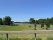 Interstate 81 highway passing through a grassy landscape near Oneida Lake with trees and a clear blue sky