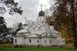 Russian Orthodox church with black and silver onion domes and crosses among autumn trees