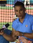 Peña in a blue MLB Network polo shirt and silver luxury watch being interviewed at a baseball field