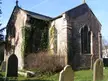 Bridges church in Beachley, a small stone church with ivy-covered walls and gravestones behind an iron fence.