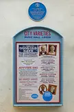 City Varieties Music Hall blue plaque and framed poster featuring celebrity lineups in black and white