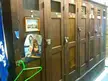 Naked blonde slim woman squatting in a pinup photo pinned to wooden lockers in a men's locker room