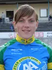 Willy Kanis wearing a blue, green, and yellow cycling jersey, featuring her red hair and blue eyes.