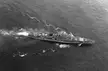 Aerial black and white photo of the naval ship Razumnyy sailing through the open sea with a white wake.