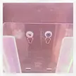 A close-up of a clear plastic holder attached to a wall with two screws, a cursed image of a sneaker box setup.