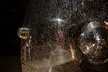 Close-up of water droplets on a reflective surface with distorted night city reflections, aesthetic 4k wallpaper