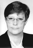 Sybille Reider in a black and white yearbook photo wearing glasses and a dark blazer over a white polka-dot shirt.