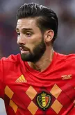 Carrasco in a red Adidas Belgium soccer jersey with a v-neck, featuring tanned skin and a beard.