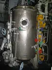 Steampunk industrial stainless steel tank with pipes, valves, and gauges in a mechanical room