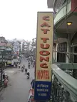 Cat Tuong Hotel sign in Hanoi with motorbikes and people in casual clothing walking on the city street